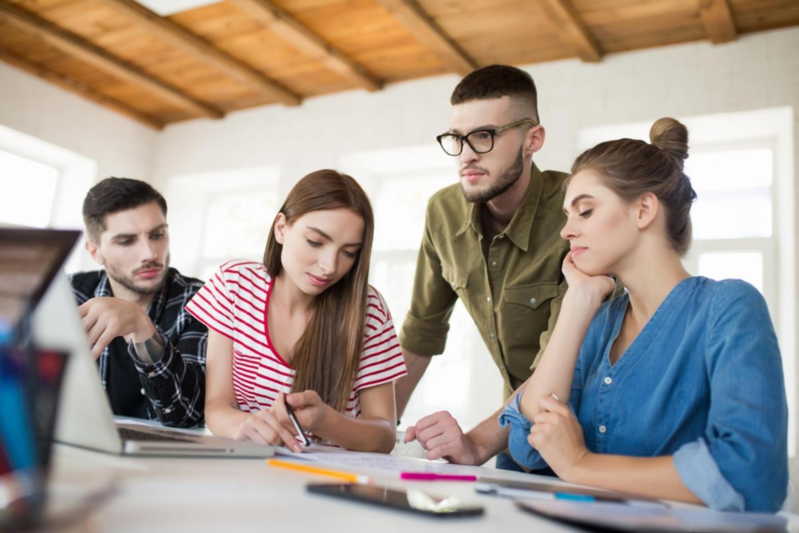 Professional team collaborating on technology project in modern office environment